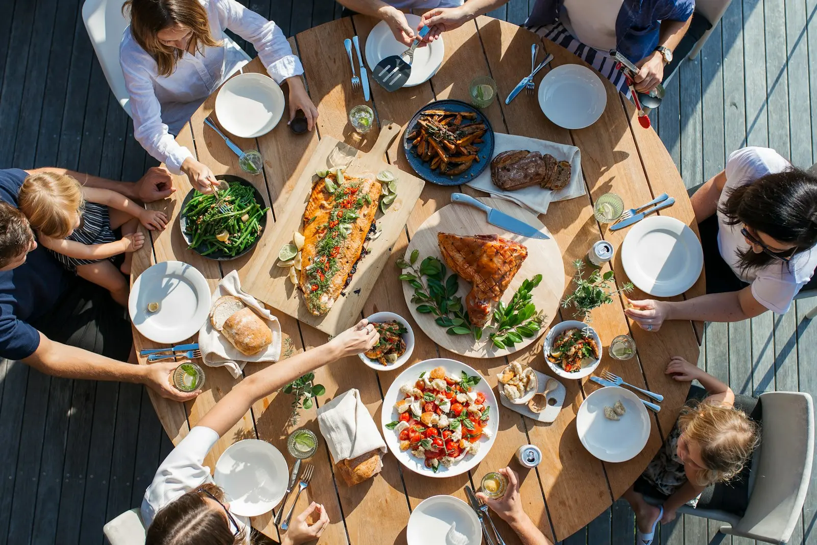 Vänner som delar flera rätter vid ett långbord, sett ovanifrån